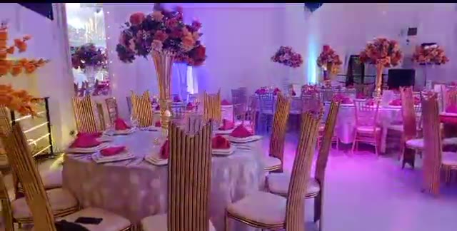 Tables des invités dressées avec chaises dorées et centres floraux